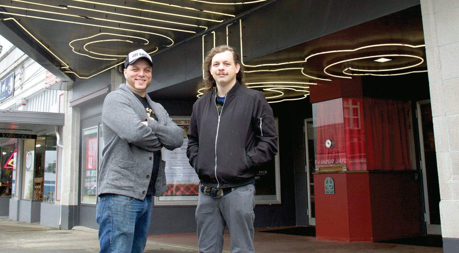 McFiler’s Chehalis Theater owner Tim Filer, left, and HUB Comedy producer Gabe Botten stand beneath a sign advertising Kabir Singh’s comedy show in Chehalis on Tuesday.